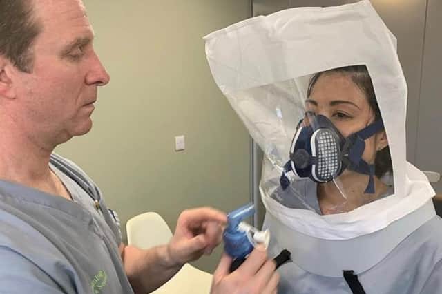 Farsley Dental Practice's Dr Jon Swarbrigg carrying out a mask fitting on dental nurse Motoko Gumbs.