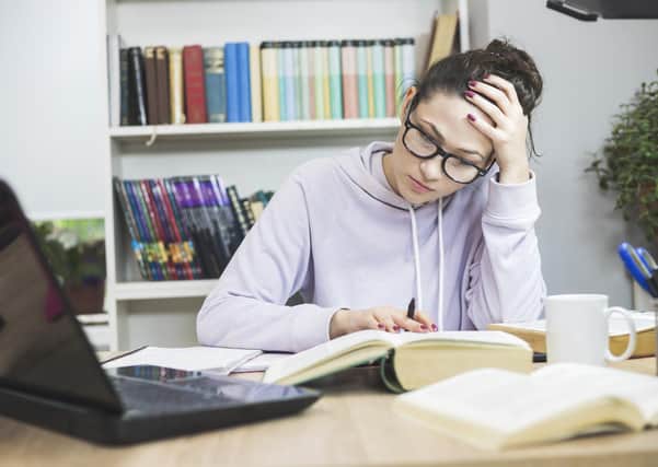 Stressed student  Doing  Homework At The Desk