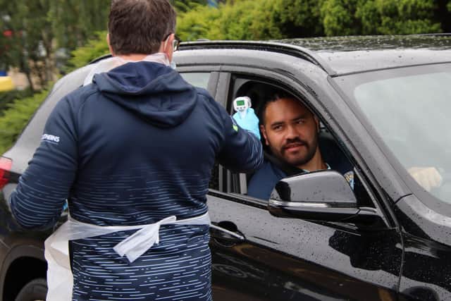 Rhinos team manager Jason Davidson takes Konrad Hurrell's temperature as he arrives for training. Picture by Phil Daly.