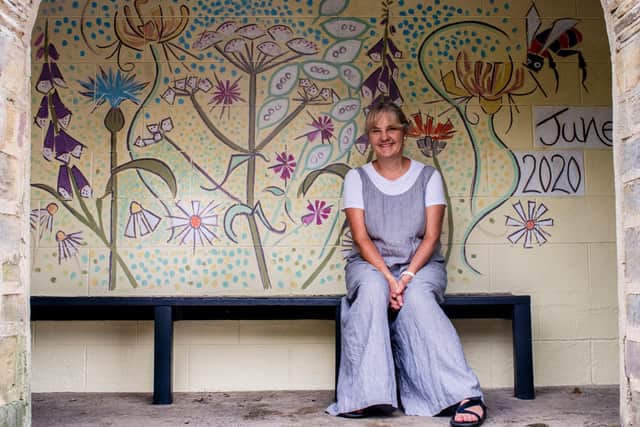 Artist Kim Coley with her bus stop mural. Photo: Ernesto Rogata