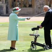 Captain Sir Thomas Moore arrives to receive his knighthood from Queen Elizabeth II during a ceremony at Windsor Castle.