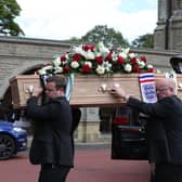 Jack Charlton's coffin is carried into a crematorium for his funeral.