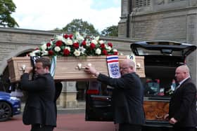 Jack Charlton's coffin is carried into a crematorium for his funeral.