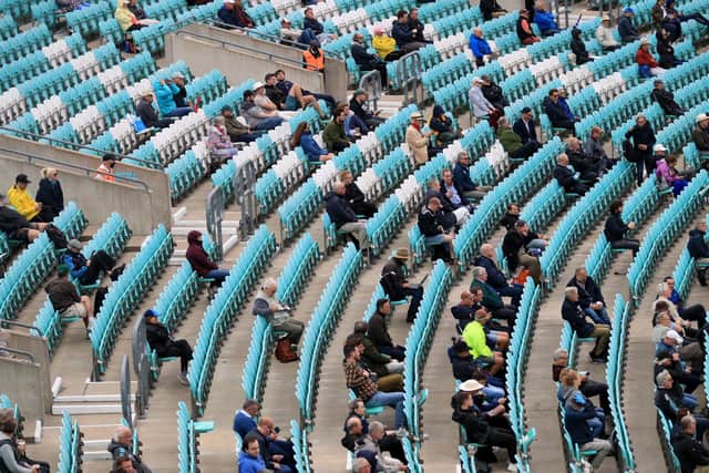 TAKE YOUR SEAT: Fans are seen sitting apart in the stands during the friendly match between Surrey and Middlesex at the Kia Oval. Picture: Adam Davy/PA