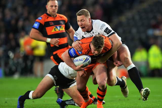 Adam Milner is tackled during Tigers' Cup defeat at Hull last year. Picture by Bruce Rollinson