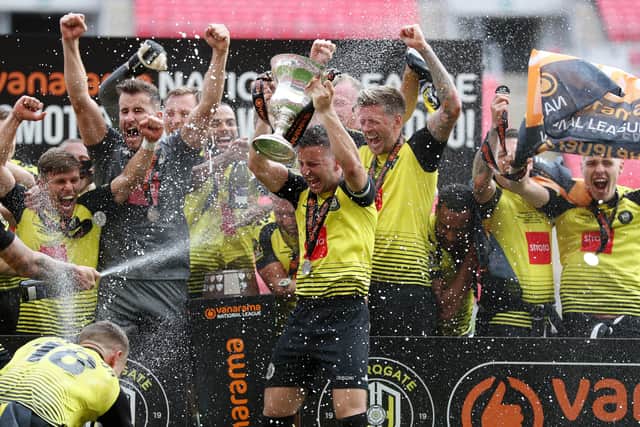 Harrogate Town captain Josh Falkingham lifts the trophy after his team's victory in the National League Play Off Final against Notts County at Wembley Stadium. Picture: Catherine Ivill/Getty Images