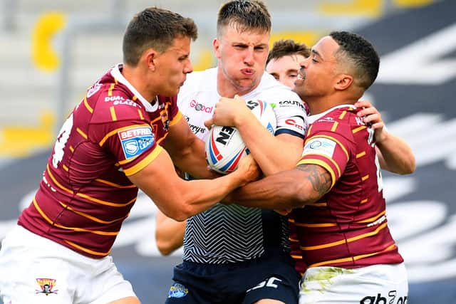 TOUGH YARDS: Leeds Rhinos' Alex Mellor is tackled by Louis Senior, and Jordan Turner, of of Huddersfield Giants. Picture: James Hardisty.