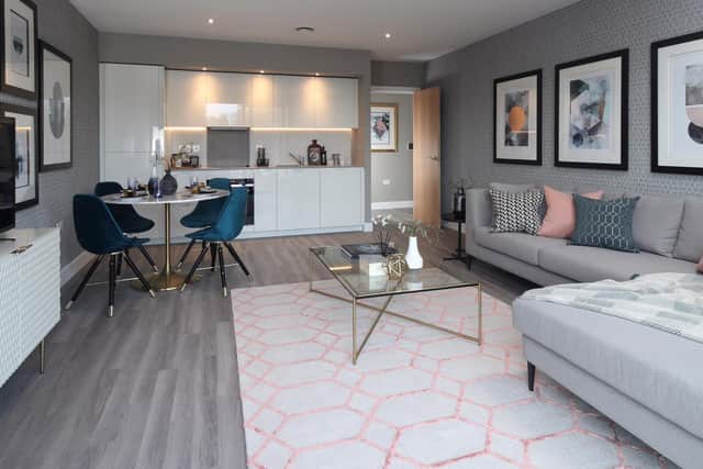 The living area is a modern open plan design, decorated in muted greys but with a splash of colour from the furniture.