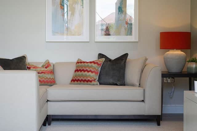 Another one of the Alwoodley Apartments features a corner sofa with warm, orange pops of colour.