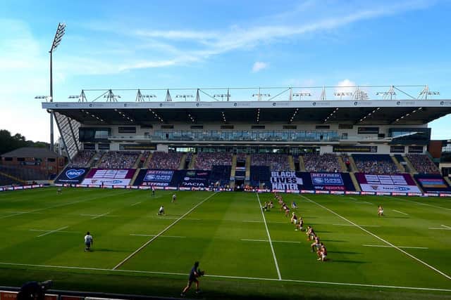 Leeds Rhinos and Huddersfield Giants players take a knee before their game at Headingley. Picture by James Hardisty.