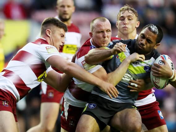 Trinity's Bill Tupou is tackled during Wigan's win at DW Stadium in July last year. Picture by Paul Currie/SWpix.com.