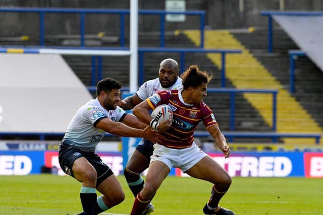 Rhyse Martin gets to grips with Huddersfield's former Leeds full-back Ashton Golding. Picture by James Hardisty.
