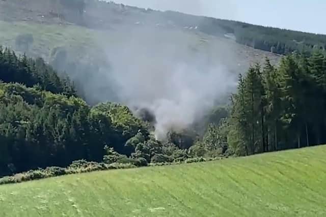 A screen grab from BBC Scotland showing smoke billowing from the train on the track in the countryside near Stonehaven, Aberdeenshire.