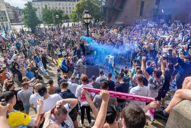 Leeds United fans celebrating promotion to the Premier League in Millennium Square.