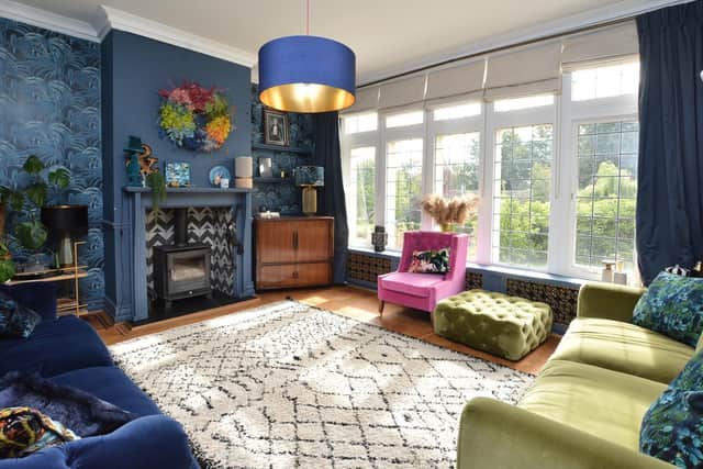 The sitting room painted in Little Greene's Hicks Blue with Palmeral wallpaper by House of Hackney