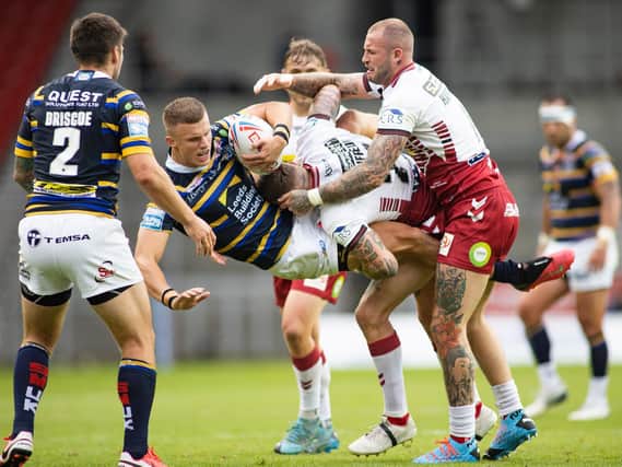 Picture by Isabel Pearce/SWpix.com - 16/08/2020 - Rugby League - Betfred Super League - Wigan Warriors v Leeds Rhinos - The Totally Wicked Stadium, Langtree Park, St Helens, England - Ash Handley of Leeds is tackled by Zak Hardaker and Dom Manfredi of Wigan.