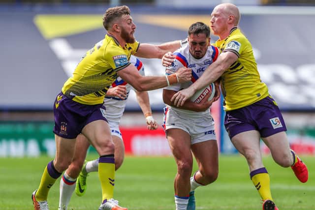 Jackson Hastings, left and Liam Farrell tackle Wakefield's Tony Gigot during Wigan's win on August 9. Picture by Alex Whitehead/SWpix.com.