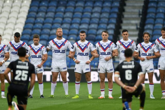 Trinity players link arms as Catalans take a knee before last Saturday's tie. Picture by Jonathan Gawthorpe.