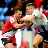 Ash Handley holds off Salford Red Devils playmaker Tui Lolohea. Picture: Steve Riding.