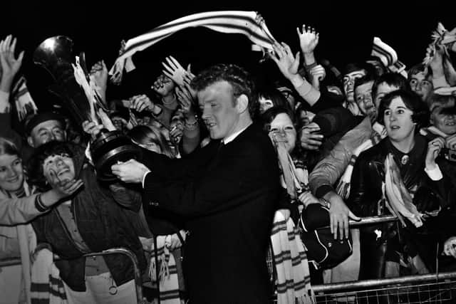 MAKE MINE A DOUBLE: Captain Billy Bremner shows Leeds United's delighted fans the Fairs Cup upon the side's homecoming after beating Ferencvaros in the final as part of a season in which they also won the League Cup. Picture by Varleys.