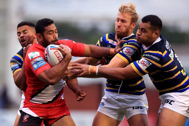 Salford Red Devils' Sebastine Ikahihifo is tackled by Leeds Rhinos' Ava Seumanufagai, Matt Prior and Robert Lui. Picture: Mike Egerton/PA Wire.