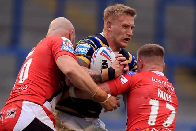 Leeds Rhinos' Mikolaj Oledzki is tackled by Salford Red Devils' Gil Dudson and Luke Yates. Picture: Mike Egerton/PA Wire.