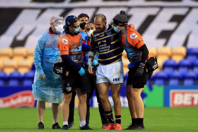Leeds Rhinos' Adam Cuthbertson is helped off the pitch after suffering a back spasm against Salford. Picture: Mike Egerton/PA Wire. 