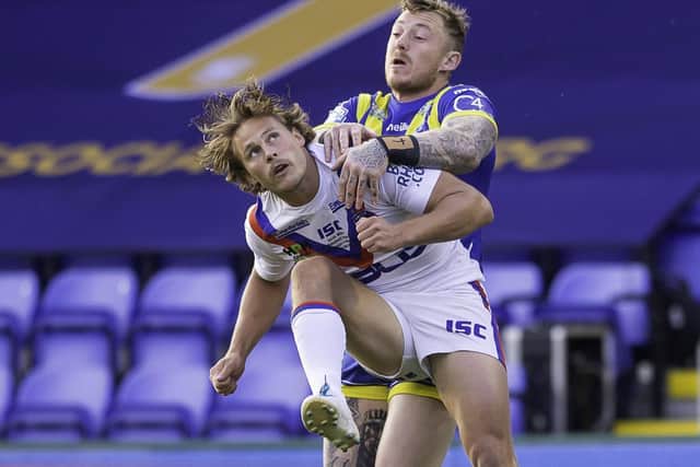 Wakefield's Jacob Miller is put under pressure by Warrington winger Josh Charnley. Picture: Allan McKenzie/SWpix.com.