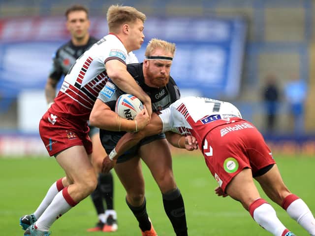 Tigers' Oliver Holmes is tackled by Wigan duo Morgan Smithies and Thomas Leuluai. Picture by Mike Egerton/PA Wire