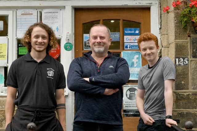 Mark Savage (centre) with sons Joseph, 21 and Oliver, 14, outside The Village Fish Shop in Shadwell.
Photo: Gary Longbottom