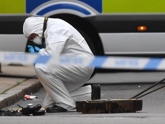 A police forensics officer taking photographs in Edmund Street in Birmingham. PIC: PA