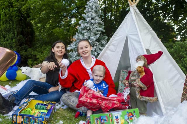 Early Xmas day celebrations for three-year-old Ellis Price from Horbury who has terminal brain cancer.
Ellis opens one of many presents with sister Caitlin and Alana, left. .
 Picture Tony Johnson