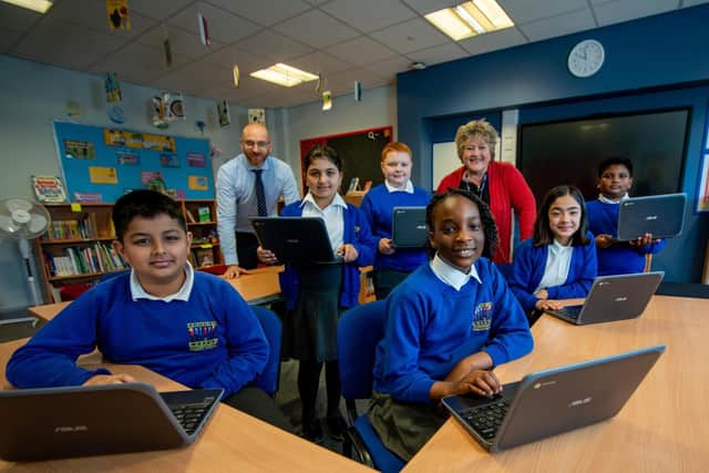 Headteacher Jill Wood and Steven Lightfoot, director of Next Generation IT with pupils at Little London Community Primary school.