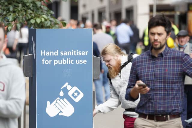 A man uses a public hand sanitiser in Leeds city centre