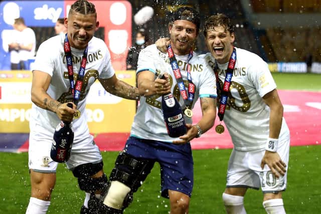 WARRIOR: The injured Gaetano Berardi, centre, celebrates Leeds United's promotion to the Premier League as Championship title winners with Kalvin Phillips, left, and Gjanni Alioski. Picture by Tim Goode/PA Wire.