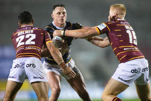 WELCOME BACK: Leeds Rhinos' James Donaldson is tackled by Huddersfield Giants' Tom Holmes and Oliver Wilson on Friday night. Picture by Isabel Pearce/SWpix.com