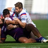 Held: Huddersfield's Suaia Matagi is tackled by Wakefield's Jay Pitts and Kyle Wood.Picture: Jonathan Gawthorpe