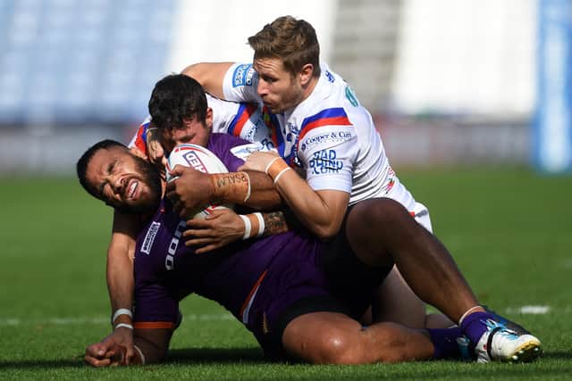 Held: Huddersfield's Suaia Matagi is tackled by Wakefield's Jay Pitts and Kyle Wood.
Picture: Jonathan Gawthorpe