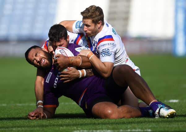 Held: Huddersfield's Suaia Matagi is tackled by Wakefield's Jay Pitts and Kyle Wood.

Picture: Jonathan Gawthorpe