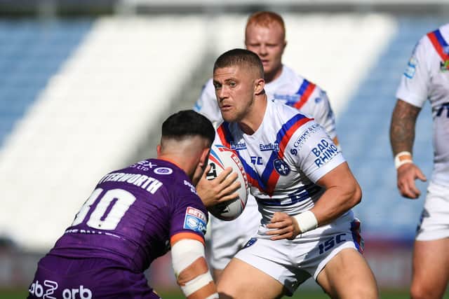 Covered: Huddersfield's Reiss Butterworth tackles Wakefield's Ryan Hampshire.
Picture: Jonathan Gawthorpe