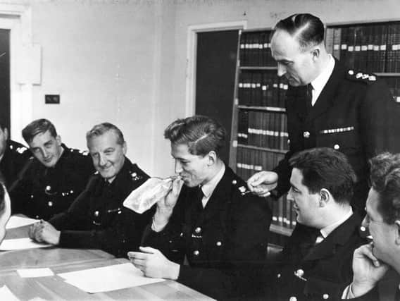 Chief Inspector Douglas Wright (standing), watches one of his class, PC Peter Farrell, from the traffic department, test the breathalyser device.