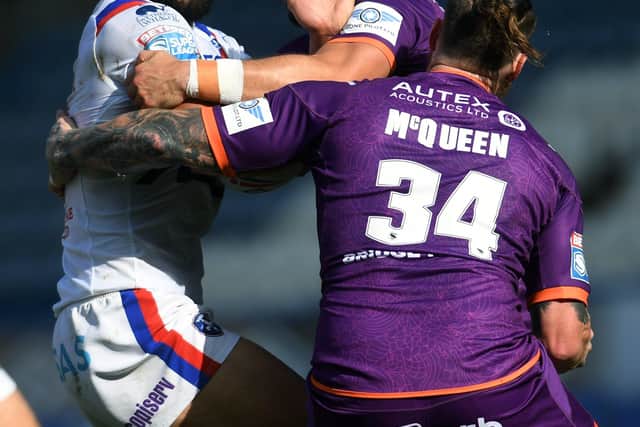 Wakefield Trinity's try scorer Kelepi Tanginoa is stopped by the Huddersfield Giants defence. Picture: Jonathan Gawthorpe/JPIMedia.