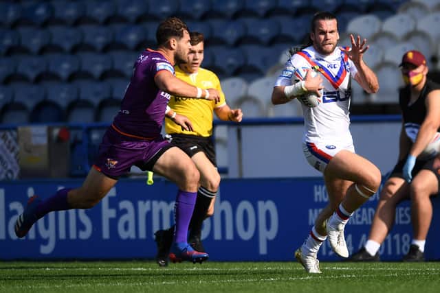 Wakefield's Liam Kay is closed down by
Huddersfield's Aidan Sezer. Picture: Jonathan Gawthorpe/JPIMedia.