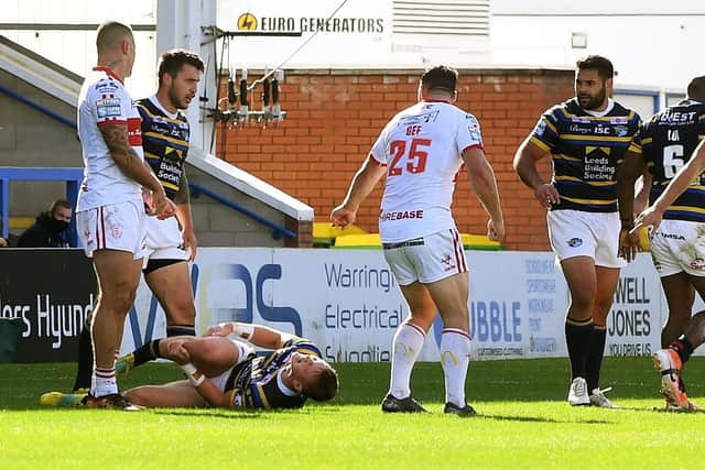 Unlucky break: Rhinos' Harry Newman lays injured as concerned players from both sides look on.
Picture: Jonathan Gawthorpe
