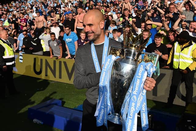 HUMBLE: Manchester City boss Pep Guardiola with the 2018-19 Premier League trophy. Photo credit should read GLYN KIRK/AFP via Getty Images.