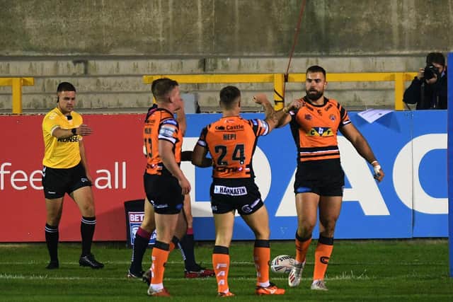 Mike McMeeken, right, celebrates his and Tigers' first try against Hull with teammate Tyla Hepi. Picture by Jonathan Gawthorpe.