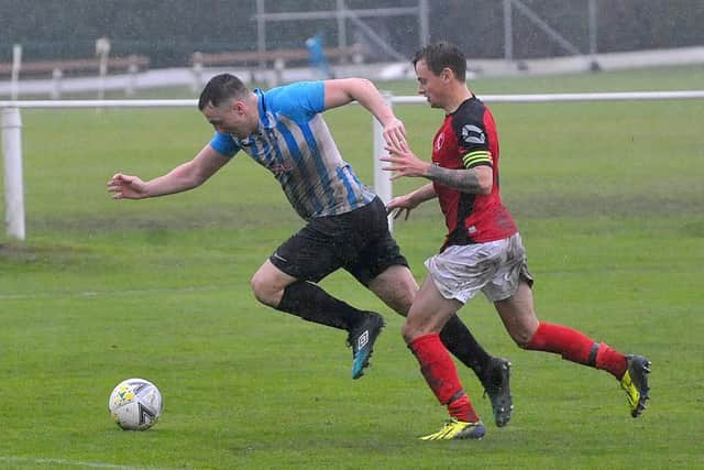 Nathan Dixon of Carlton Athletic takes on Horbury Town defender Luke Playford. Picture: Steve Riding.