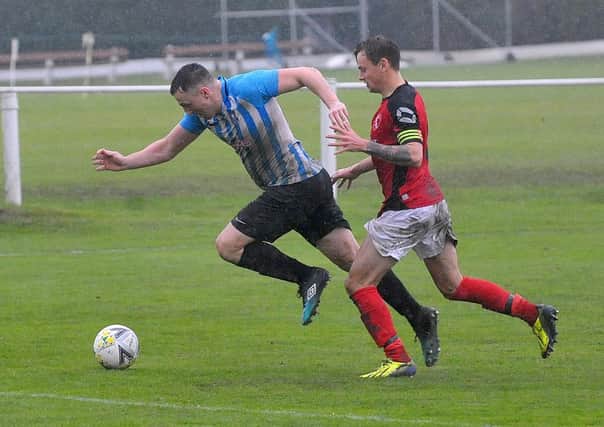 Nathan Dixon of Carlton Athletic takes on Horbury Town defender Luke Playford. Picture: Steve Riding.