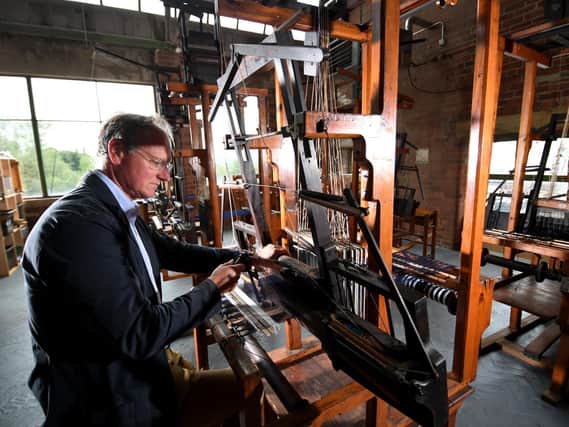 William Gaunt pictured with the 100-year-old hand looms, at Sunny Bank Mills, Farsley, Leeds. (Simon Hulme).