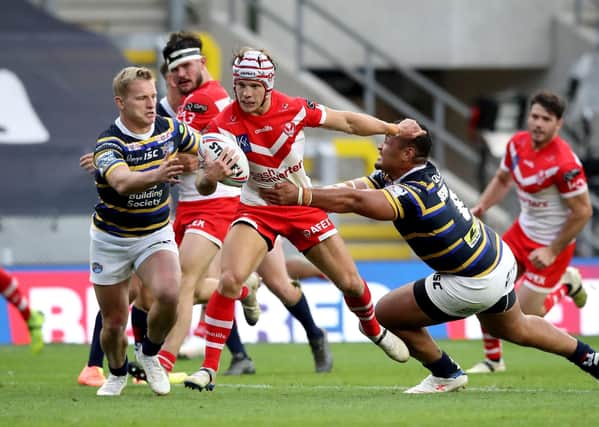 St Helens' Theo Fages (centre) is tackled by Leeds Rhinos' Brad Dwyer(left) and Ava Seumanufagai when the two sides last met at Emerald Headingley on August 9, Saints winning 48-0. Picture: Martin Rickett/PA
